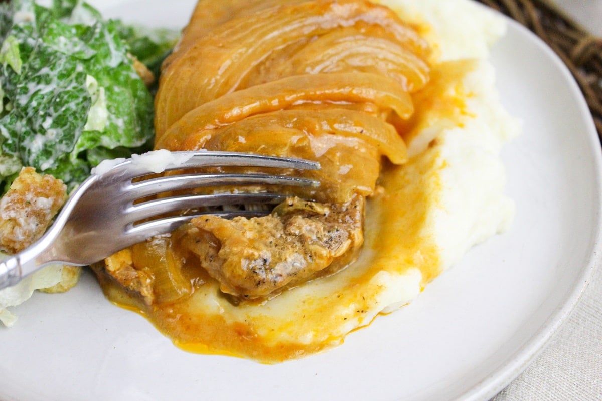 pork chops on a plate cut with a fork
