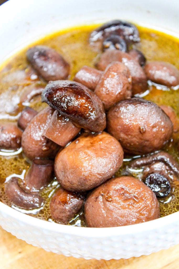 mushrooms in a white bowl with a spoon