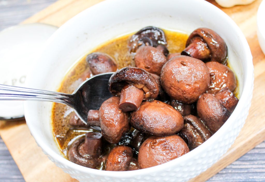 mushrooms in a white bowl with a spoon