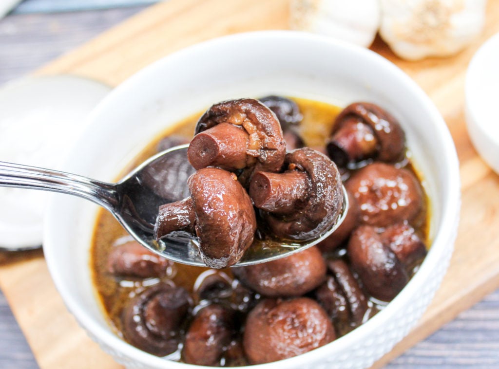 mushrooms in a white bowl with a spoon