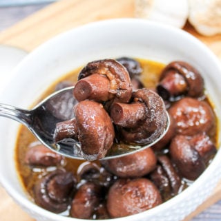 mushrooms in a white bowl with a spoon