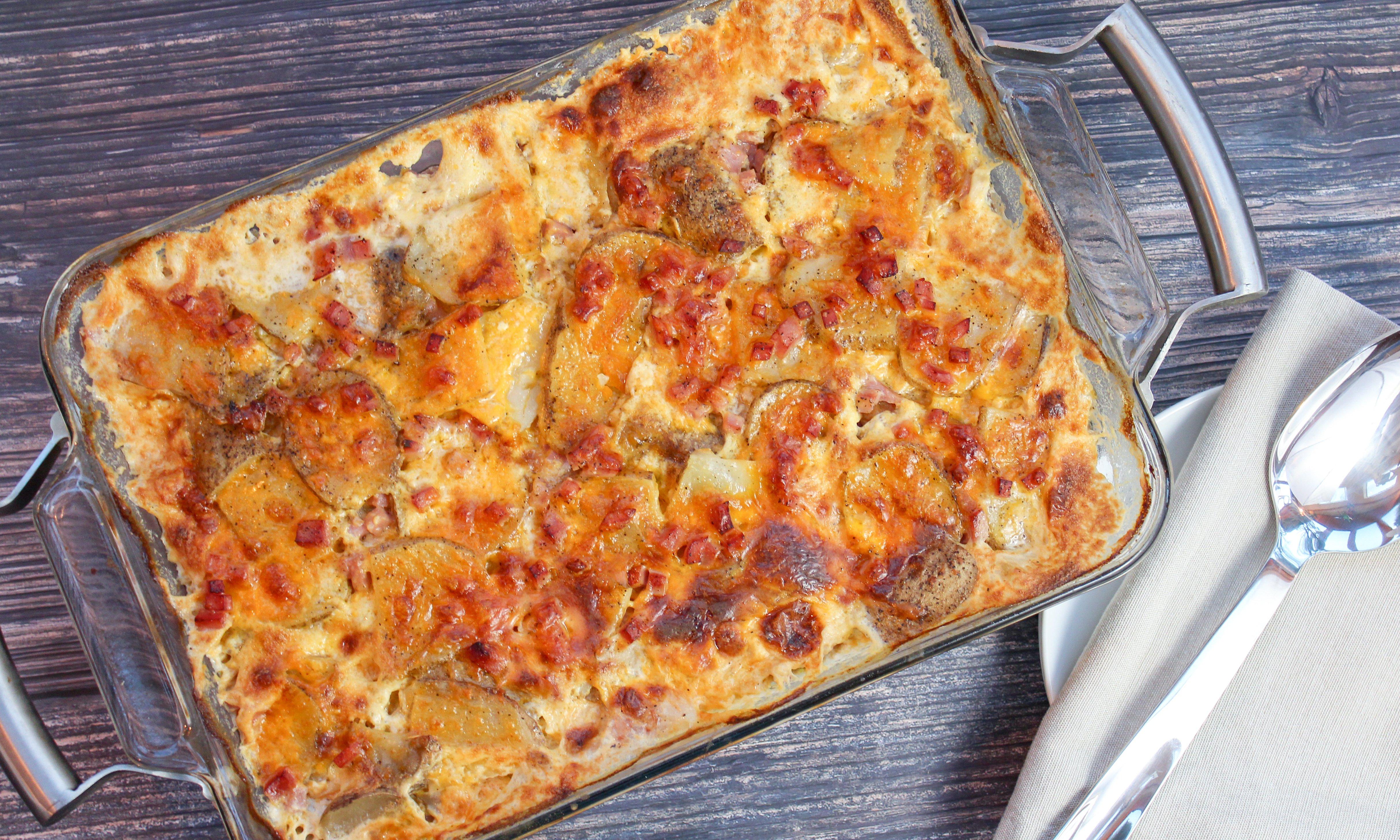 Sliced potatoes, cheese, and diced ham baked in a casserole dish