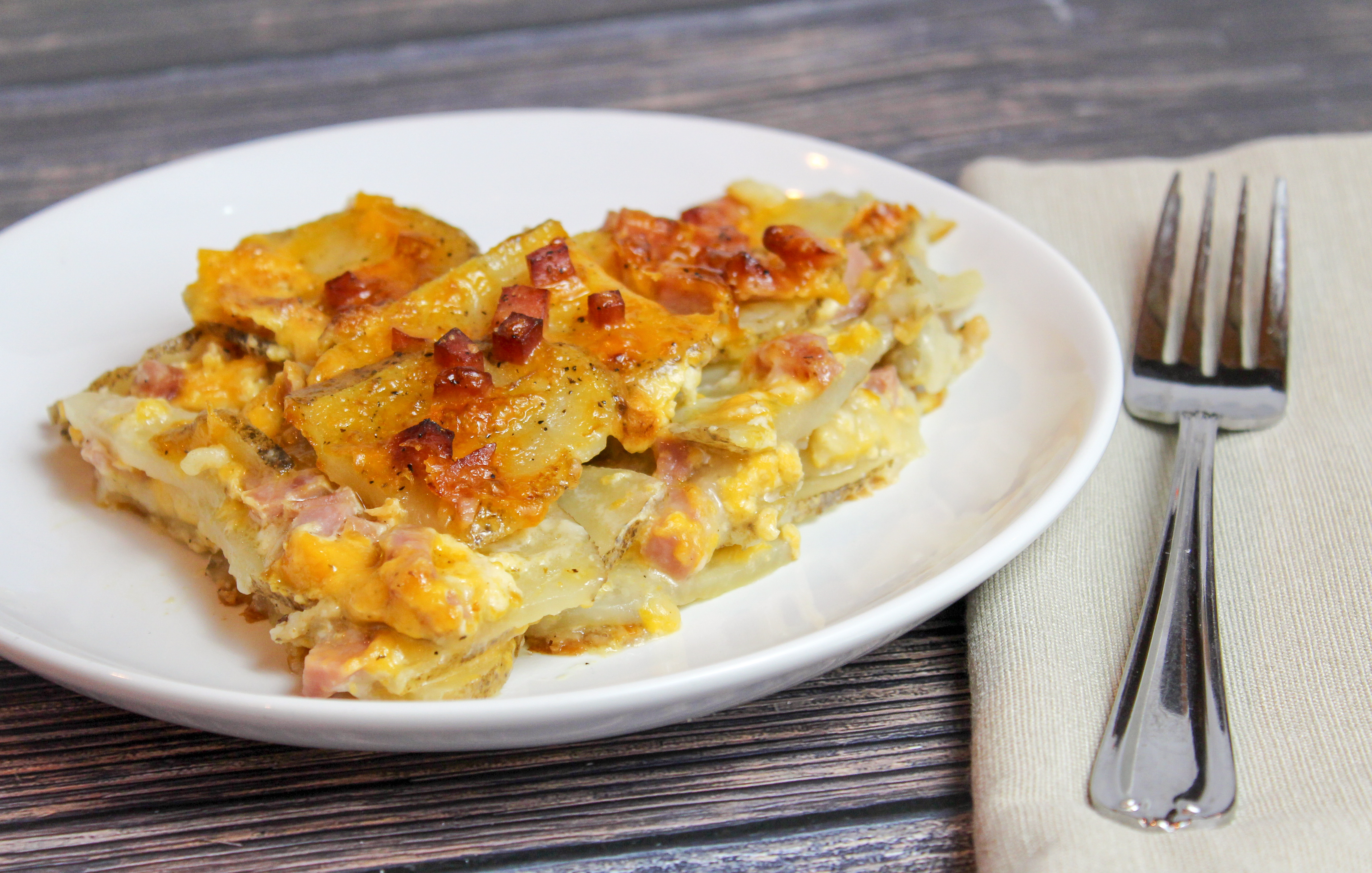 Sliced potatoes, cheese, and diced ham baked in a casserole dish