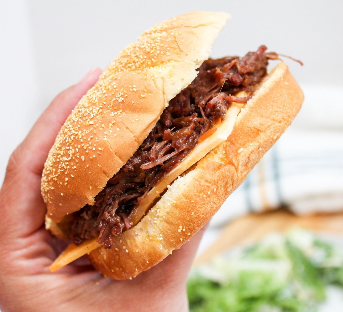 slow cooker hot beef sandwich held in hand