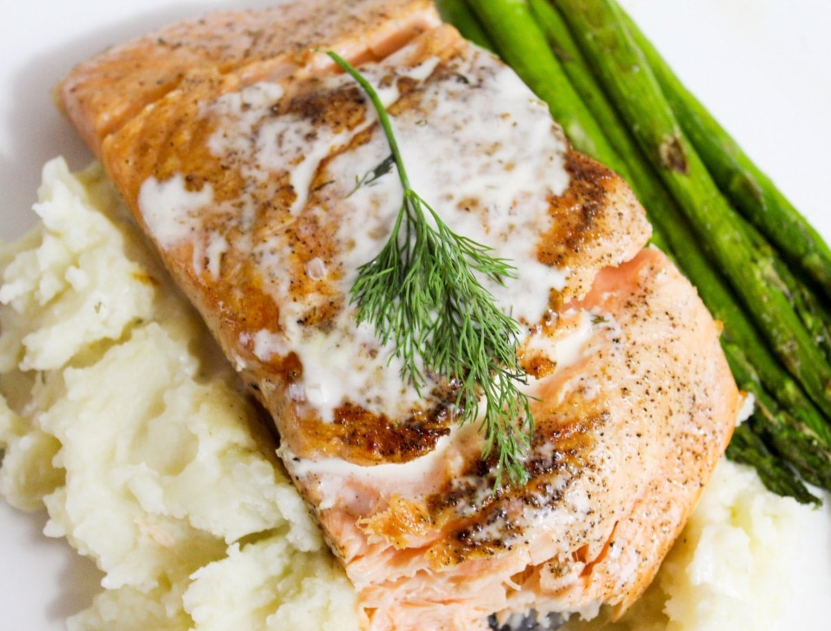 salmon with champagne sauce and dill on top