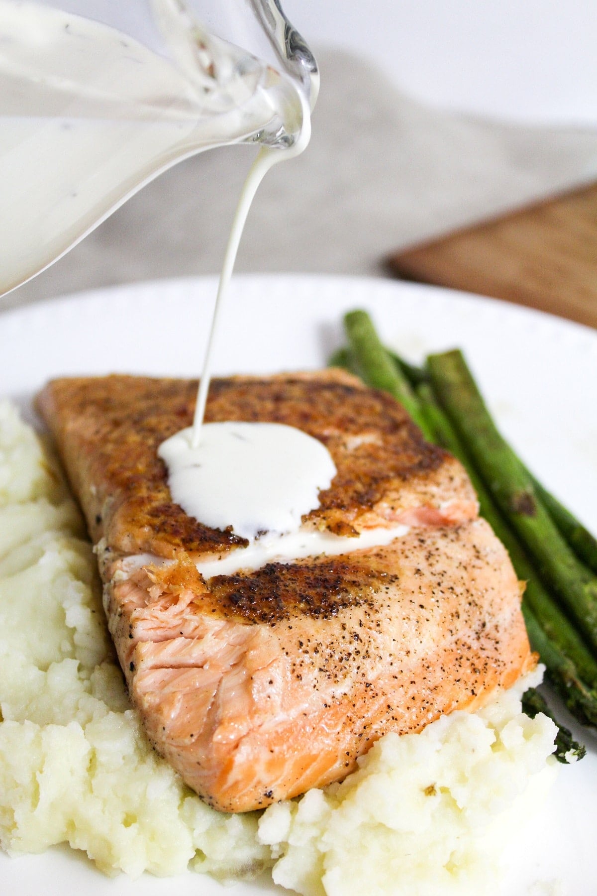 salmon with champagne sauce and dill on top poured on top