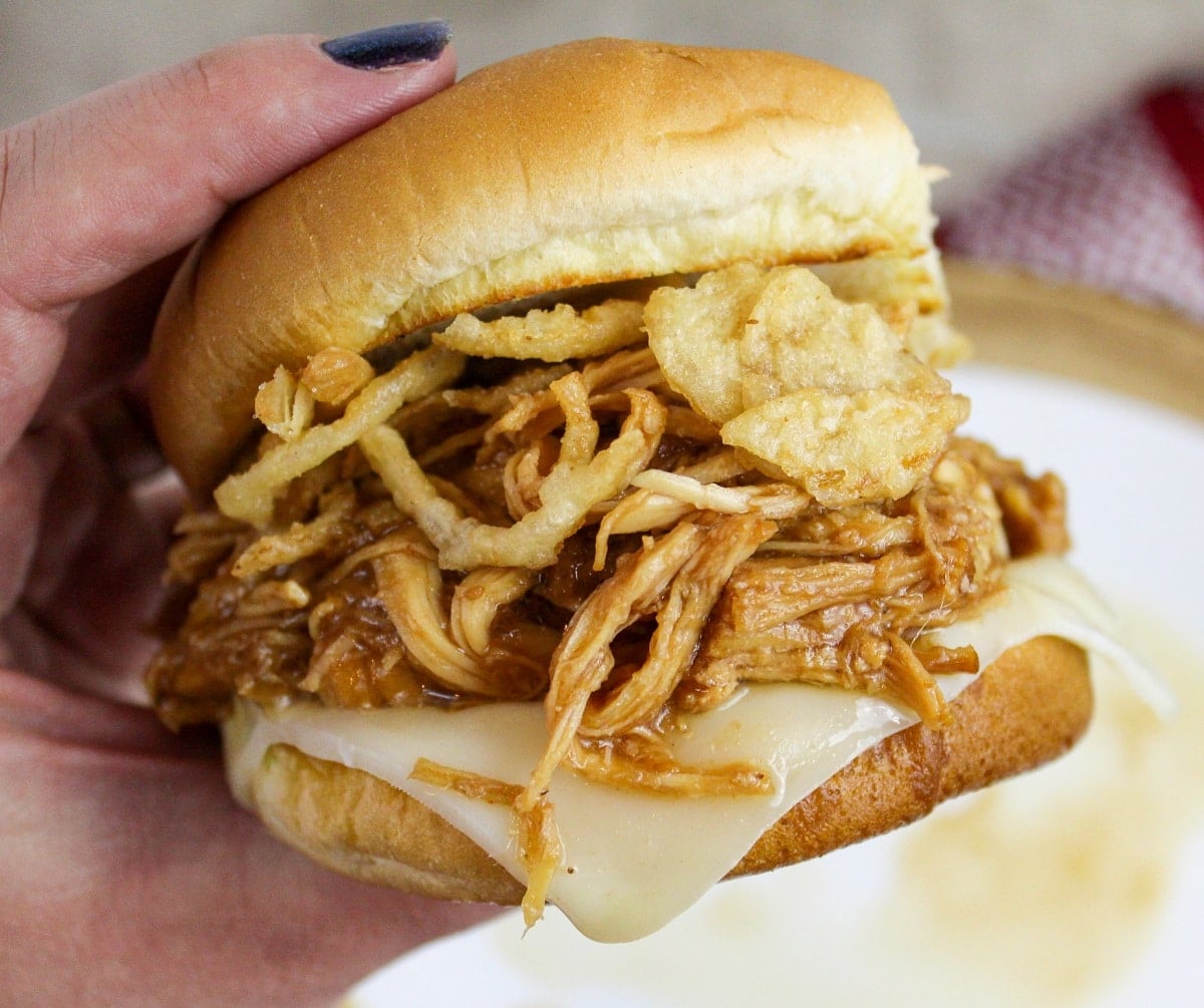 bbq cranberry chicken on a bun held in hand