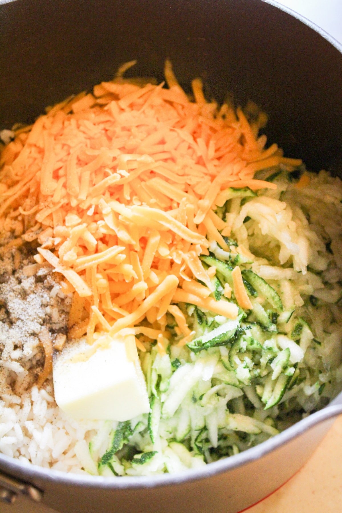 ingredients for zucchini rice in a pot not stirred together