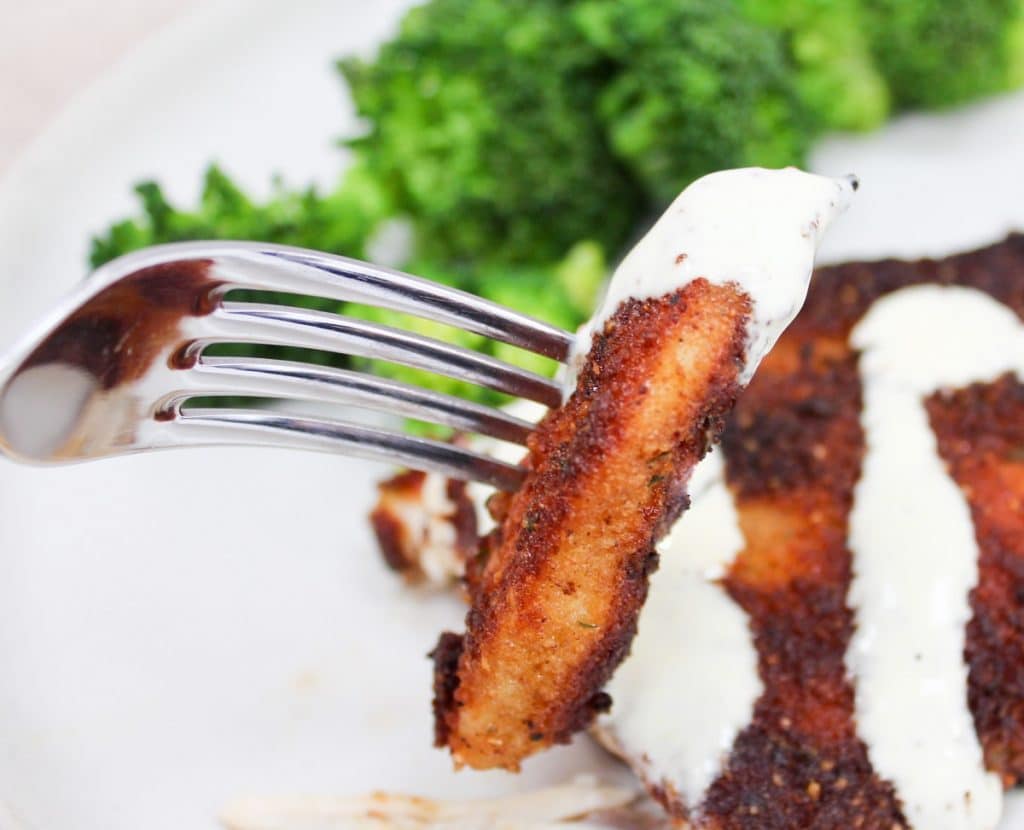 cut Crispy Parmesan Chicken with Lemon Hollandaise on a fork