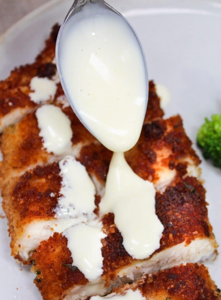 sauce spooned over Crispy Parmesan Chicken with Lemon Hollandaise