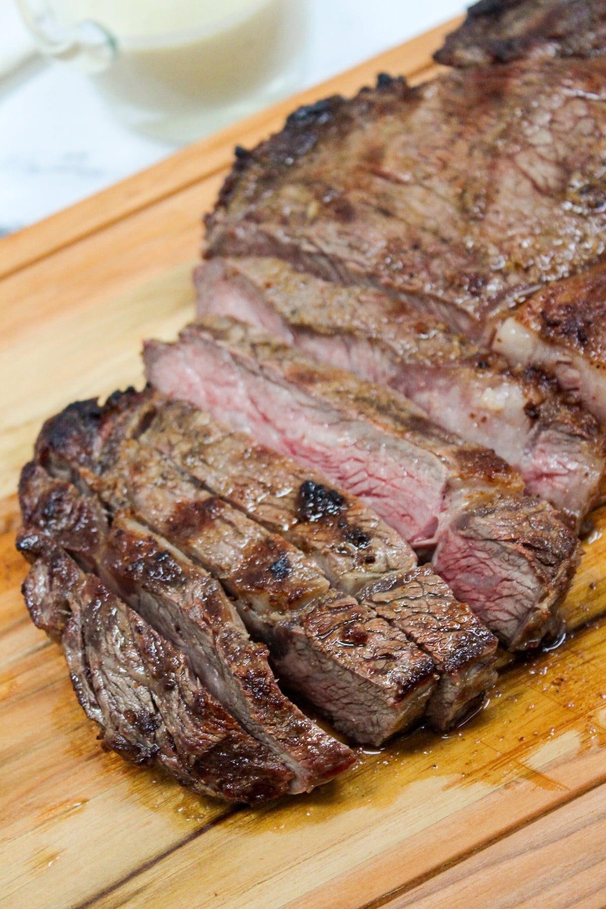 Grilled Ribeye with Garlic Blue Cheese Mustard Sauce on a cutting board and sliced
