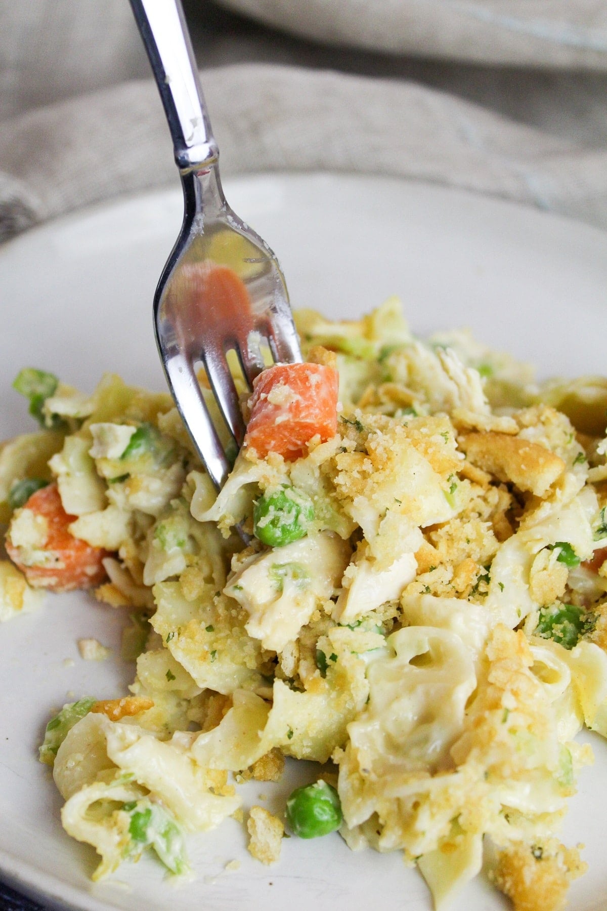 creamy chicken noodle casserole plated and eaten with a fork