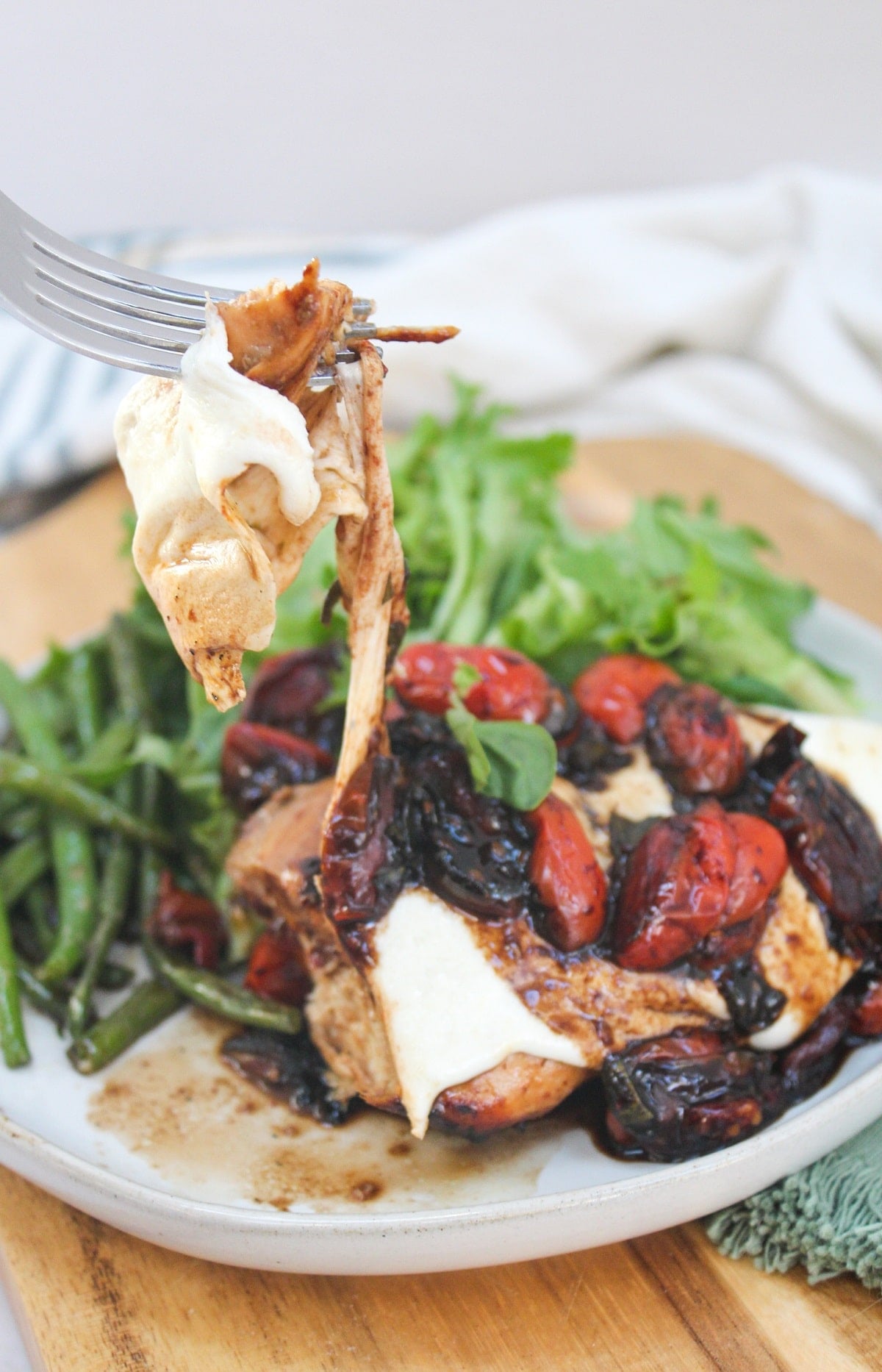 grilled caprese chicken cut and on a fork.