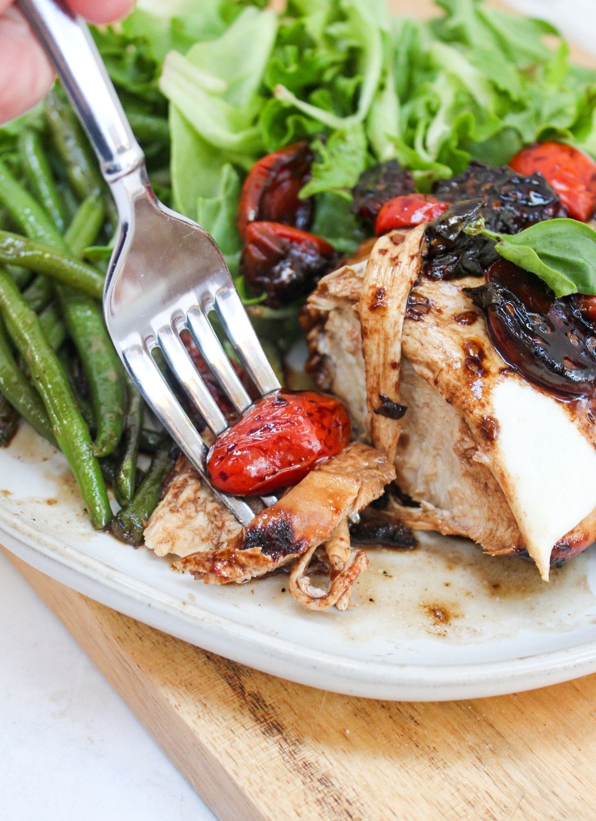 grilled caprese chicken cut and on a fork.