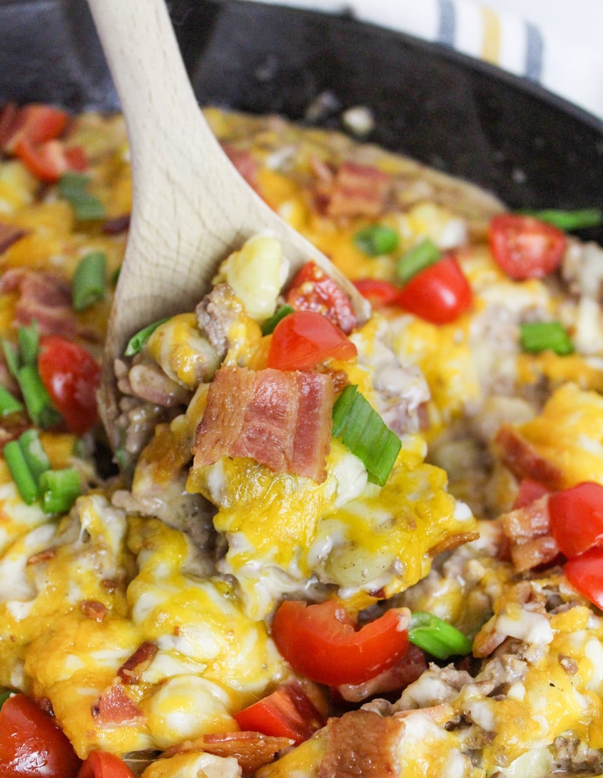 Bacon Cheeseburger Gnocchi Skillet in cast iron skillet scooped with a spoon
