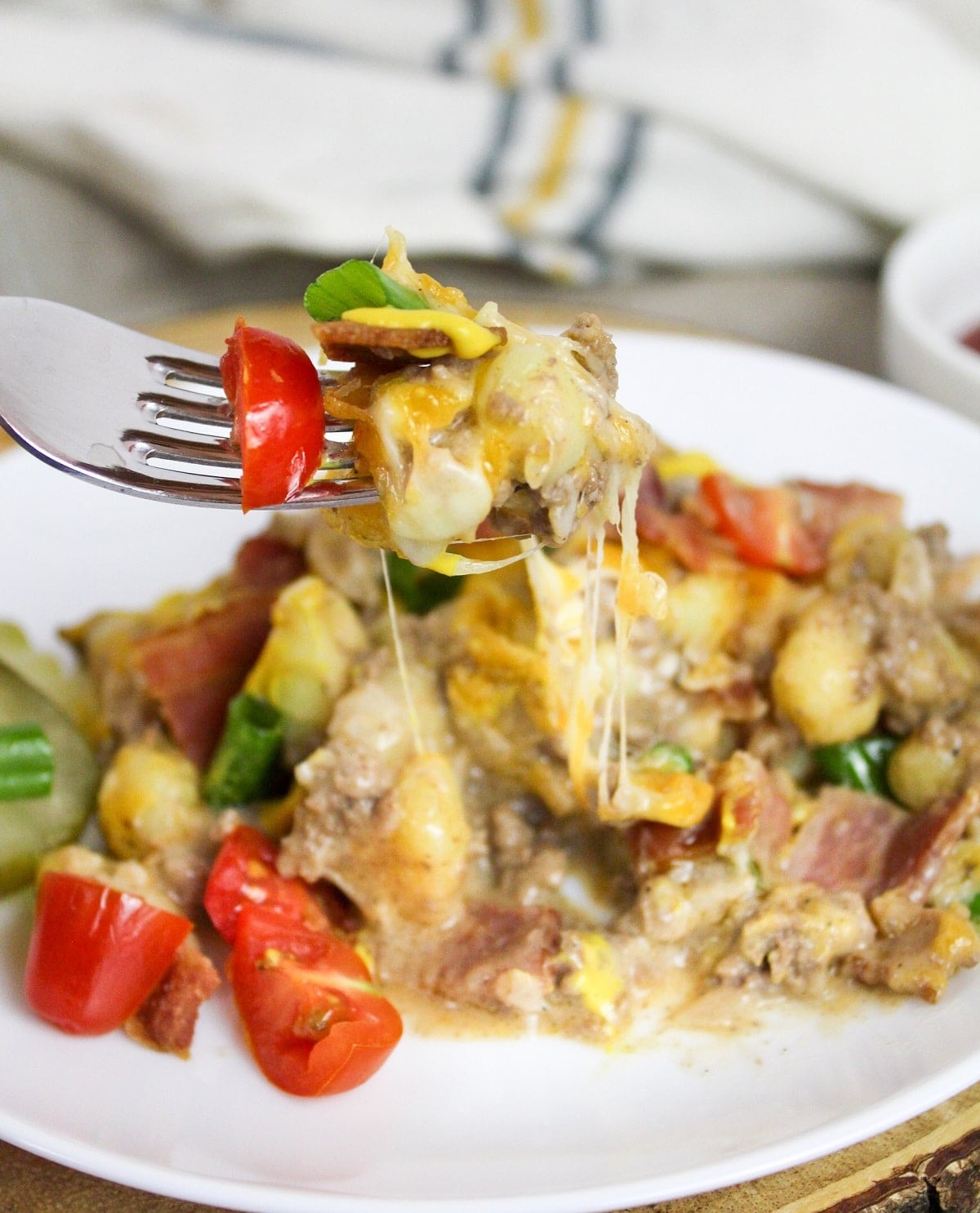 Bacon Cheeseburger Gnocchi Skillet plated and on a fork lifted in the air