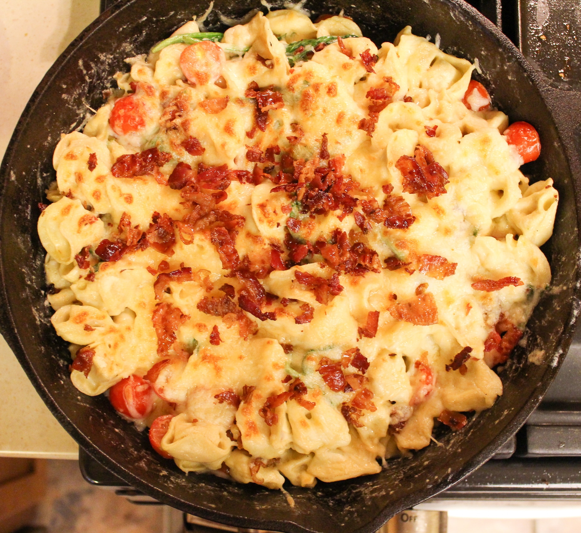 pasta in skillet topped with bacon