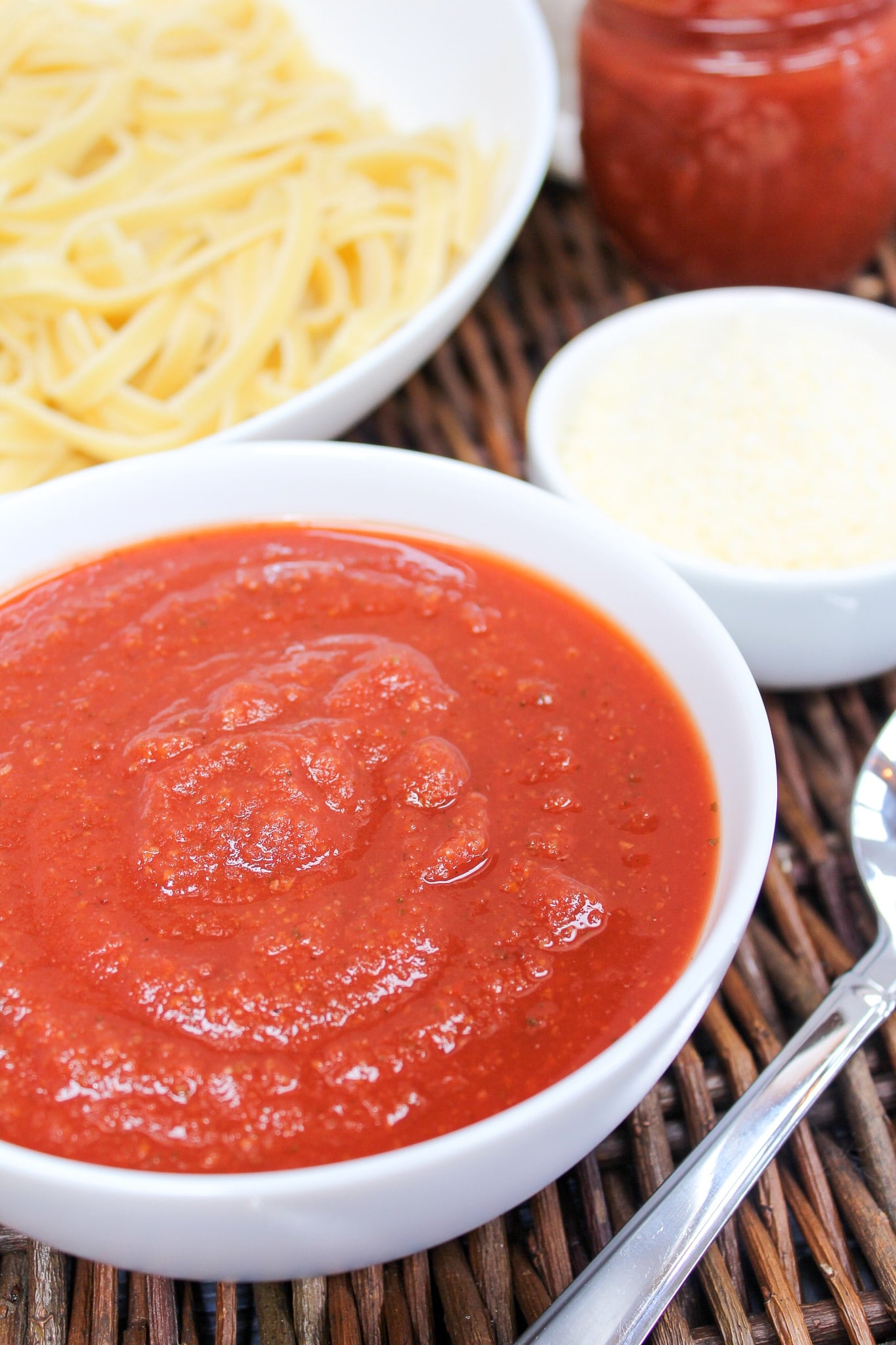 marinara sauce in a bowl with pasta in the background