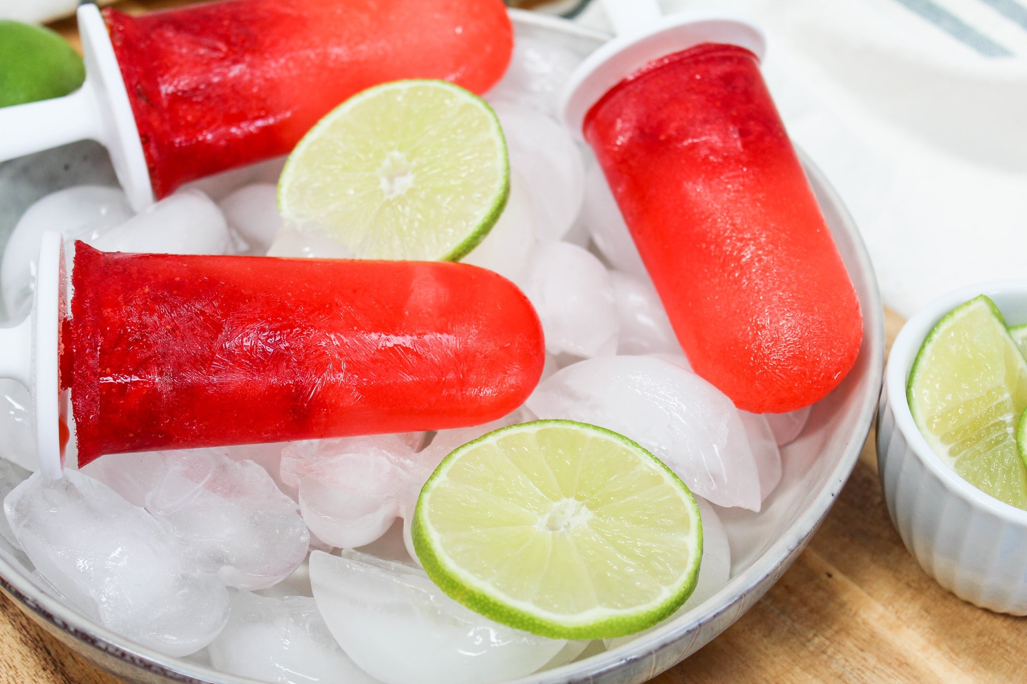 Strawberry Margarita Popsicle over ice with limes