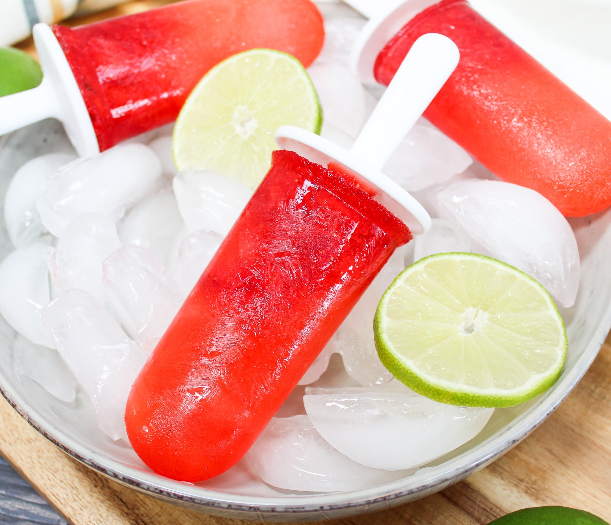 Strawberry Margarita Popsicle over ice with limes