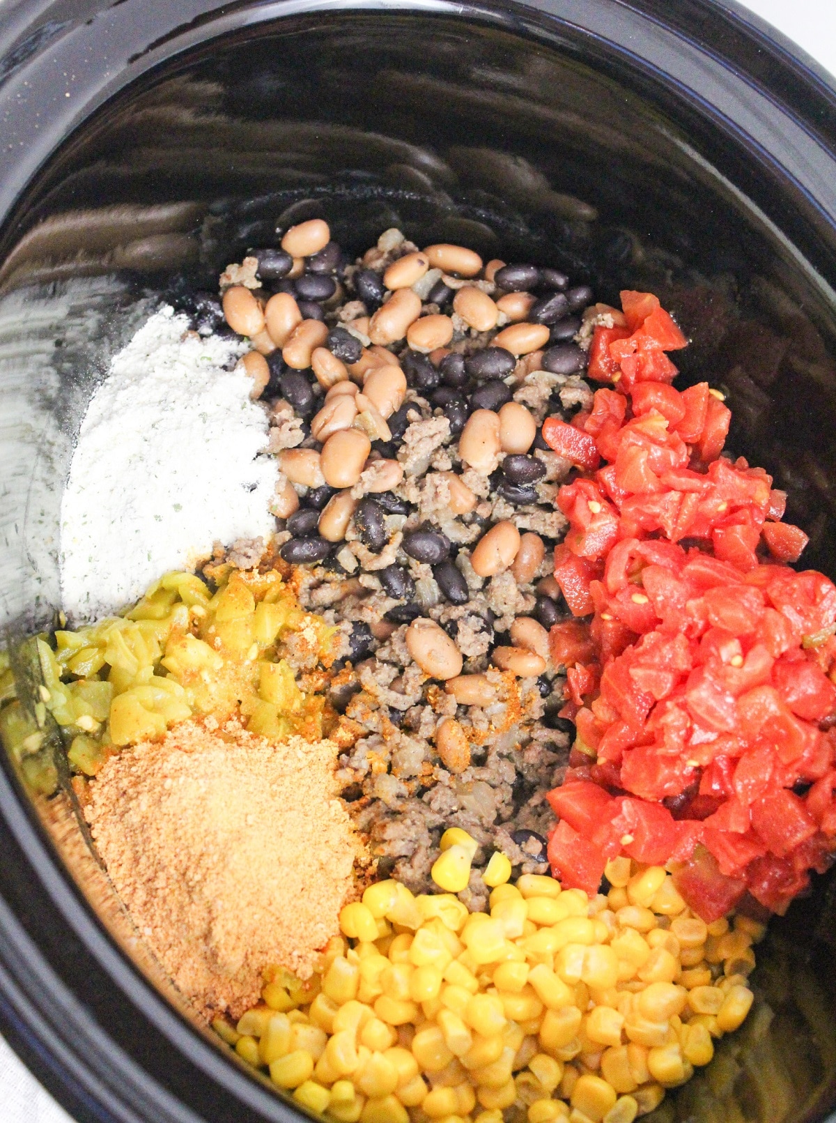 uncooked taco soup ingredients in a slow cooker