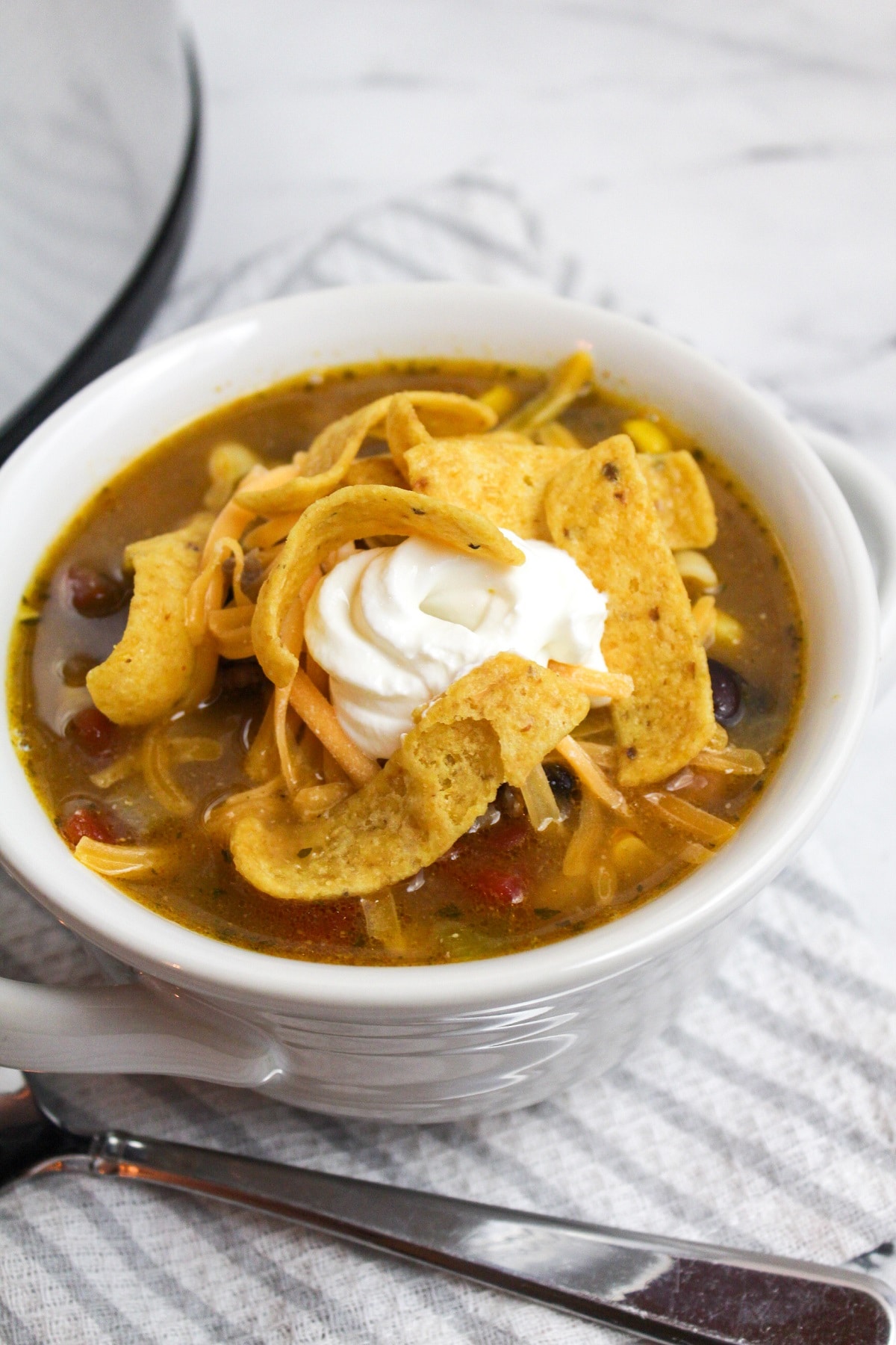 taco soup in bowl with sour cream and fritos