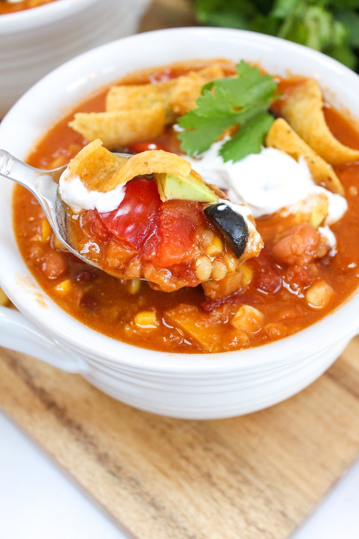 instant pot vegetarian lentil tortilla soup in a white bowl and on a spoon