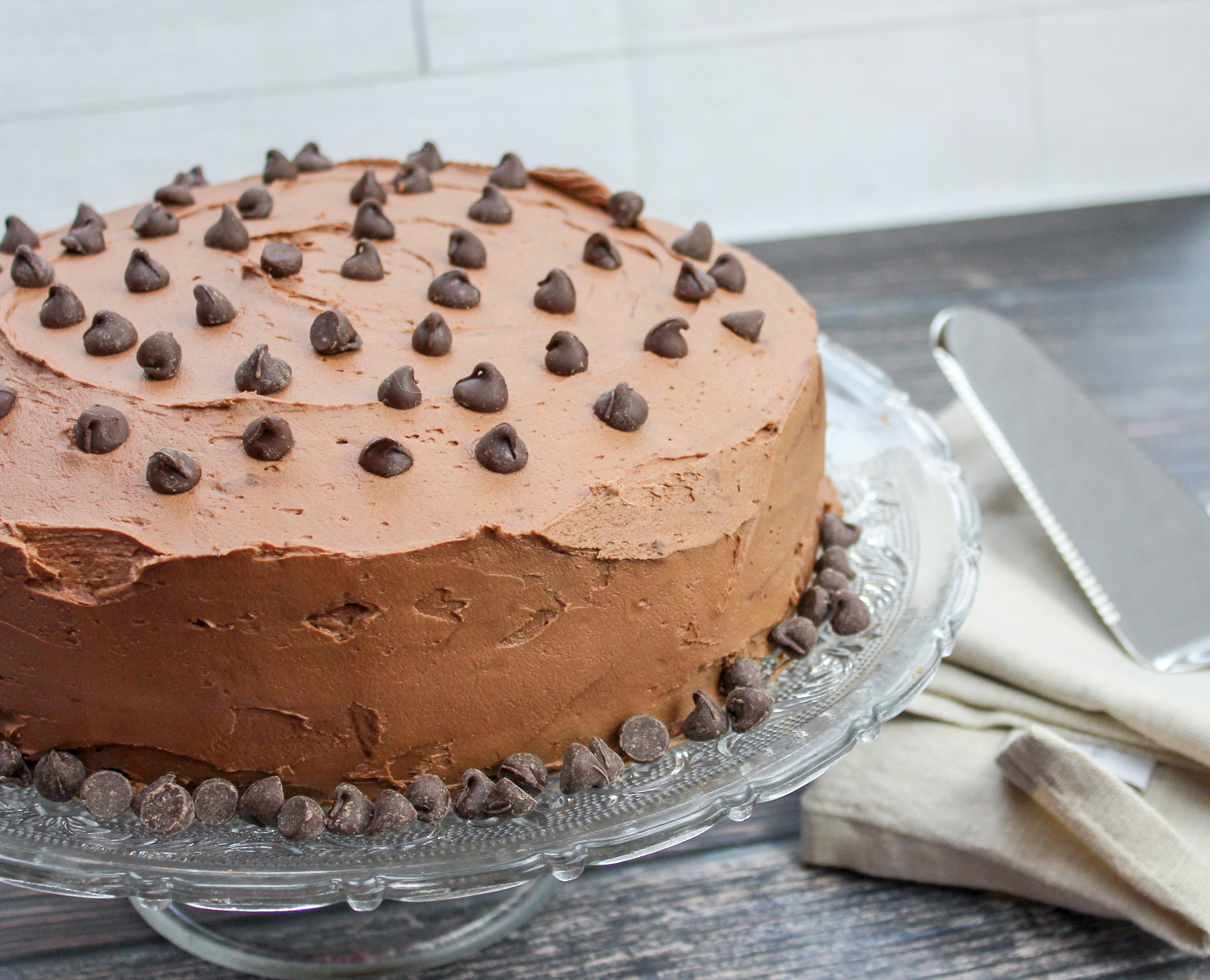 Full round cake with chocolate buttercream and topped with chocolate chips