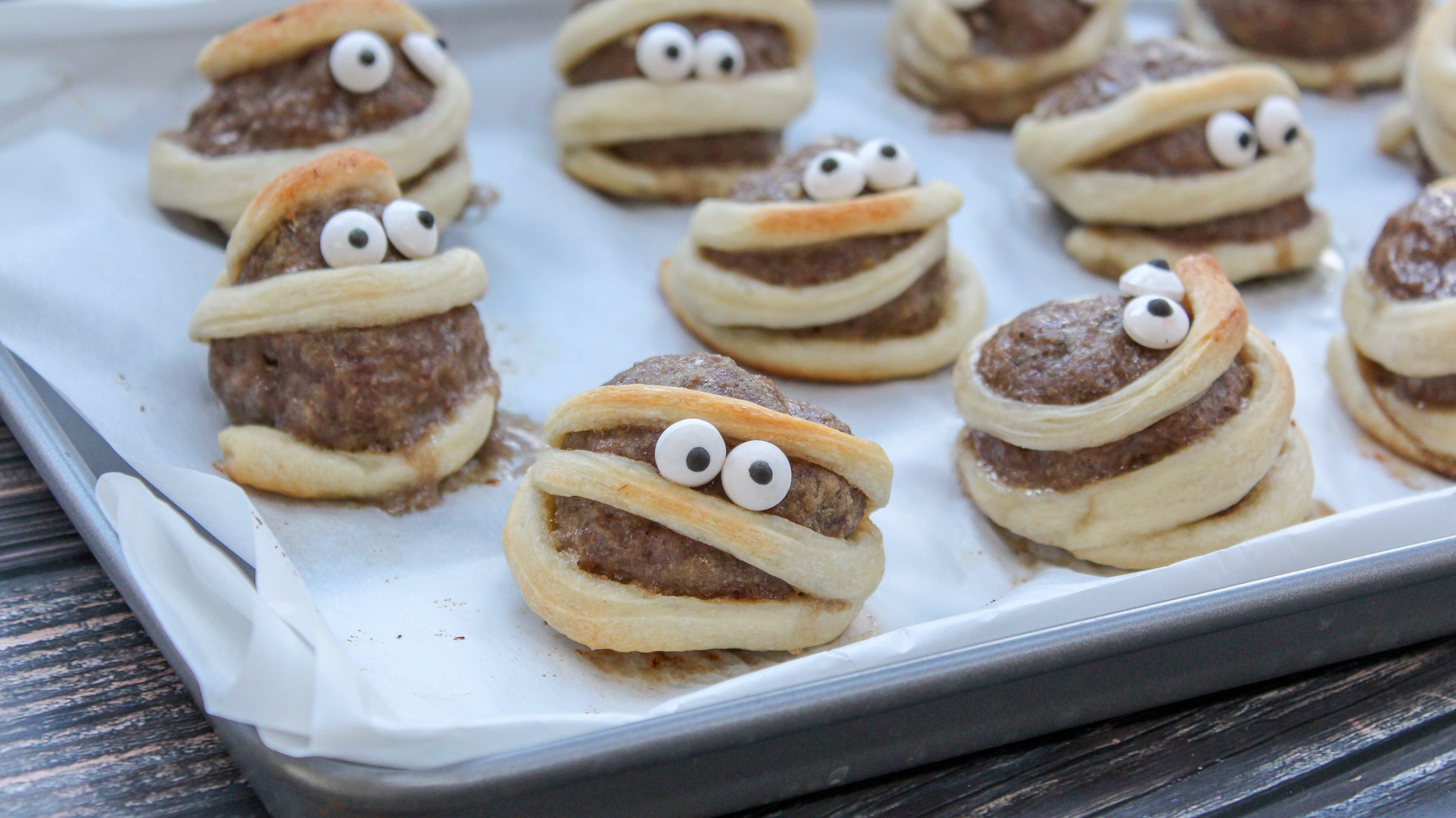 Meatballs wrapped in a strip of dough with candy eyes
