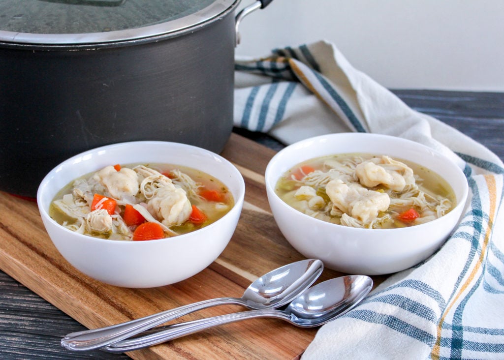 chicken dumpling soup in white bowls