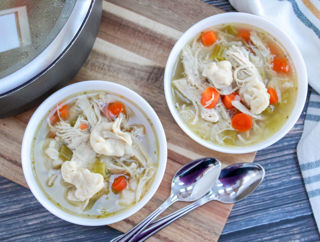 chicken dumpling soup in white bowls