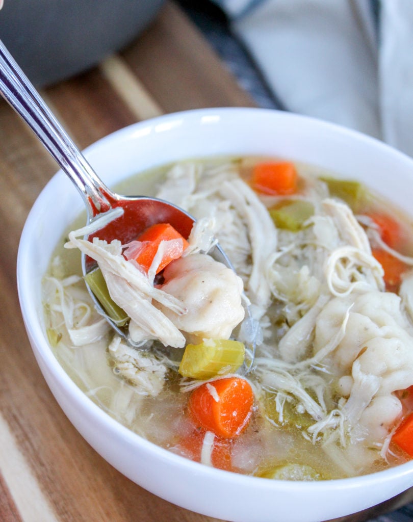 chicken dumpling soup in white bowls