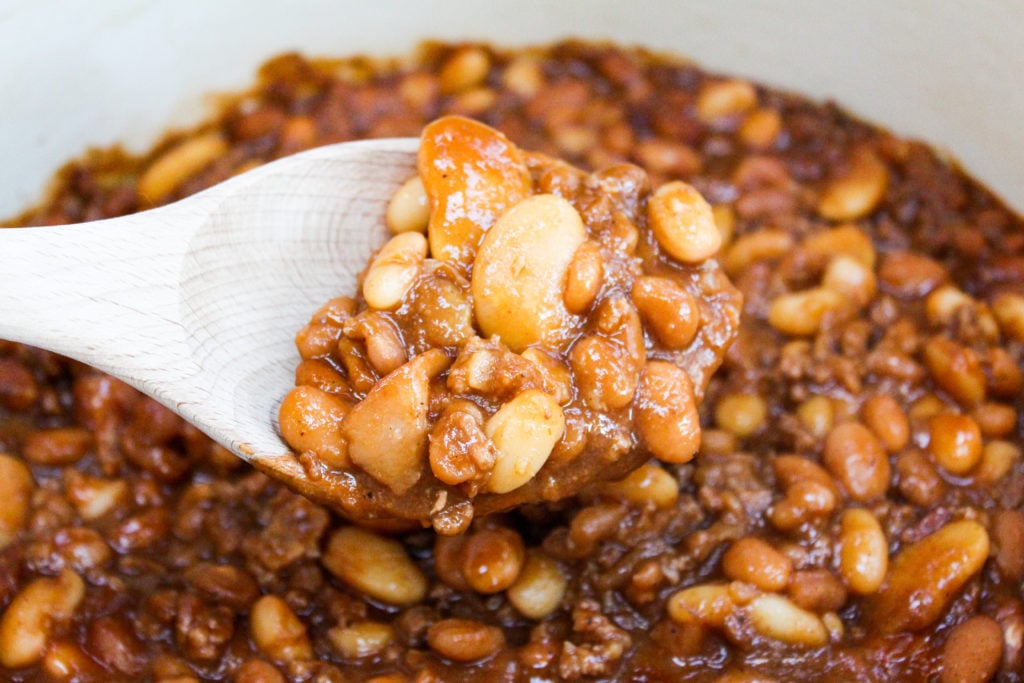 Baked beans in a pot with a wooden spoon