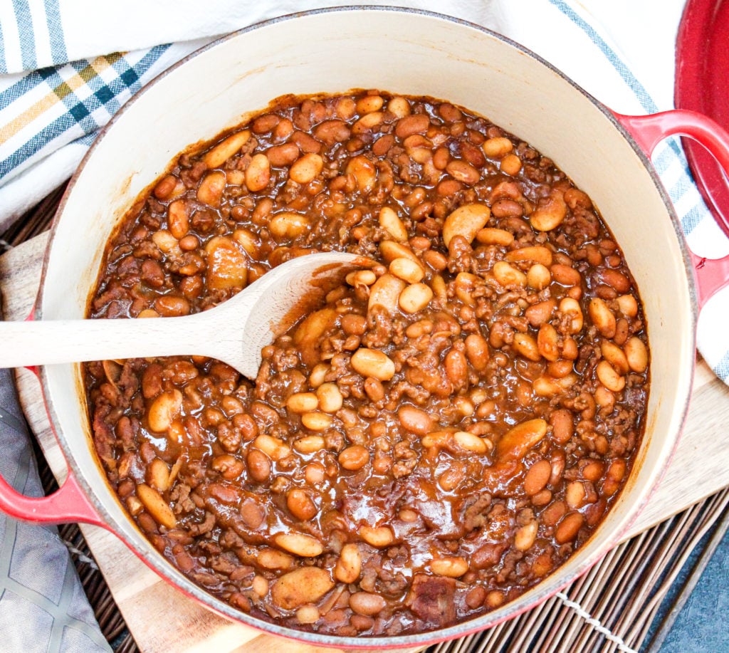 Baked beans in a pot with a wooden spoon