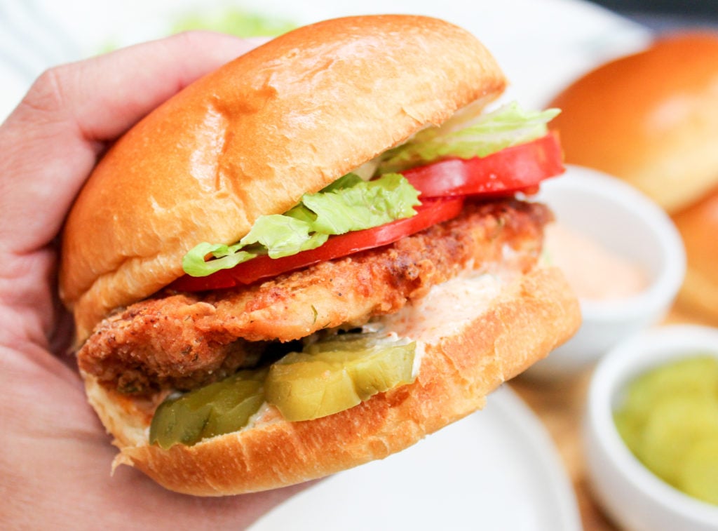 chicken sandwiches held in hand