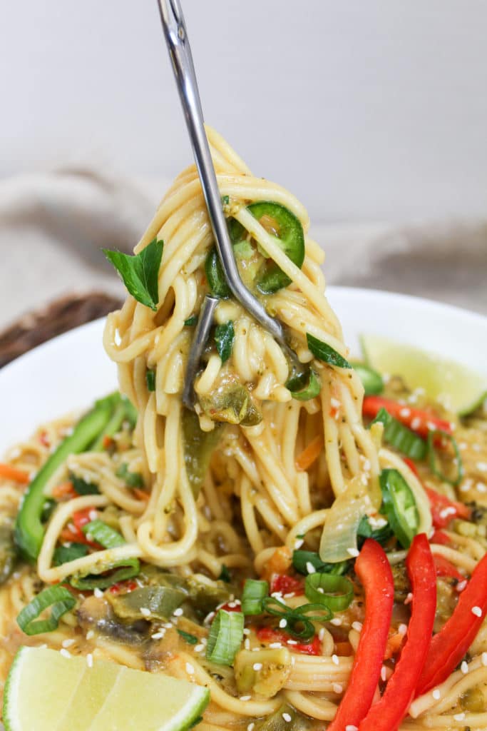 yellow curry noodle bowl in a bowl with a fork