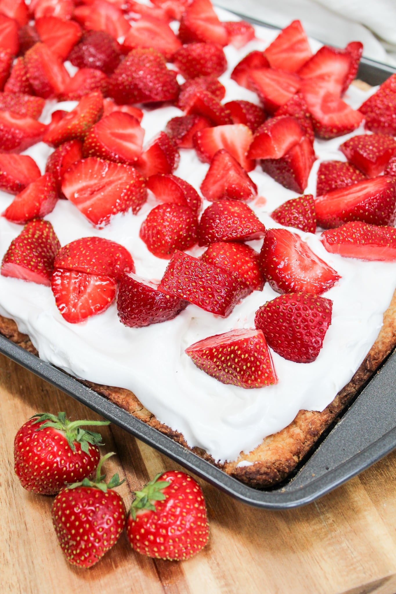uncut photo of cake with whipped cream and strawberries