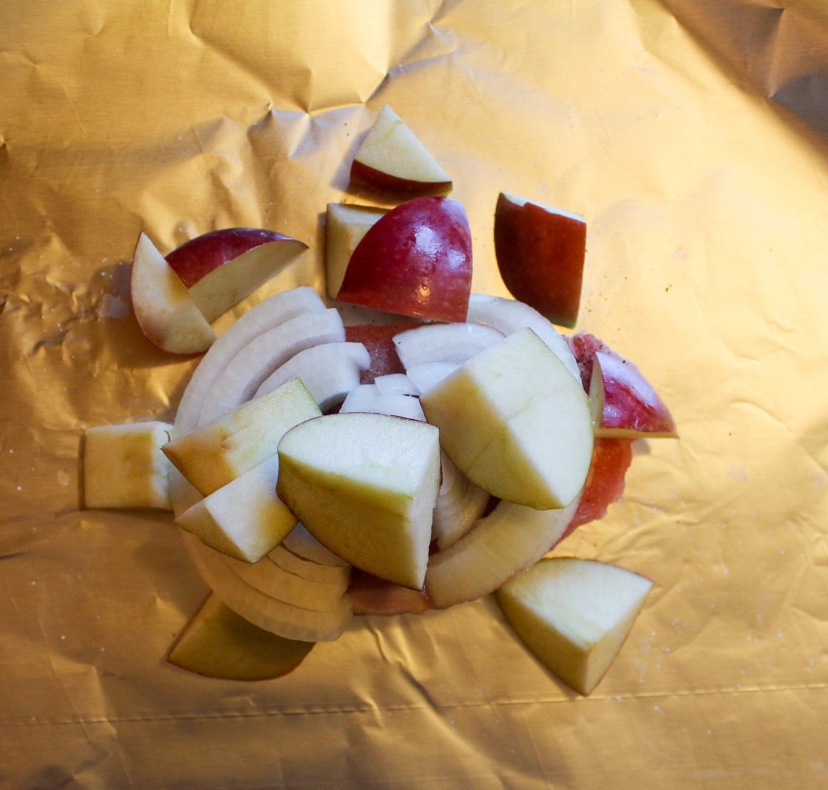 sliced onions and apples over the pork chop on foil