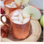 apple cider mule in a copper mug with an apple slice as a garnish