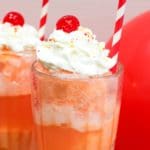 ice cream float in a glass with whipped cream and a cherry