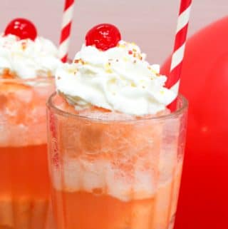 ice cream float in a glass with whipped cream and a cherry