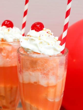 ice cream float in a glass with whipped cream and a cherry