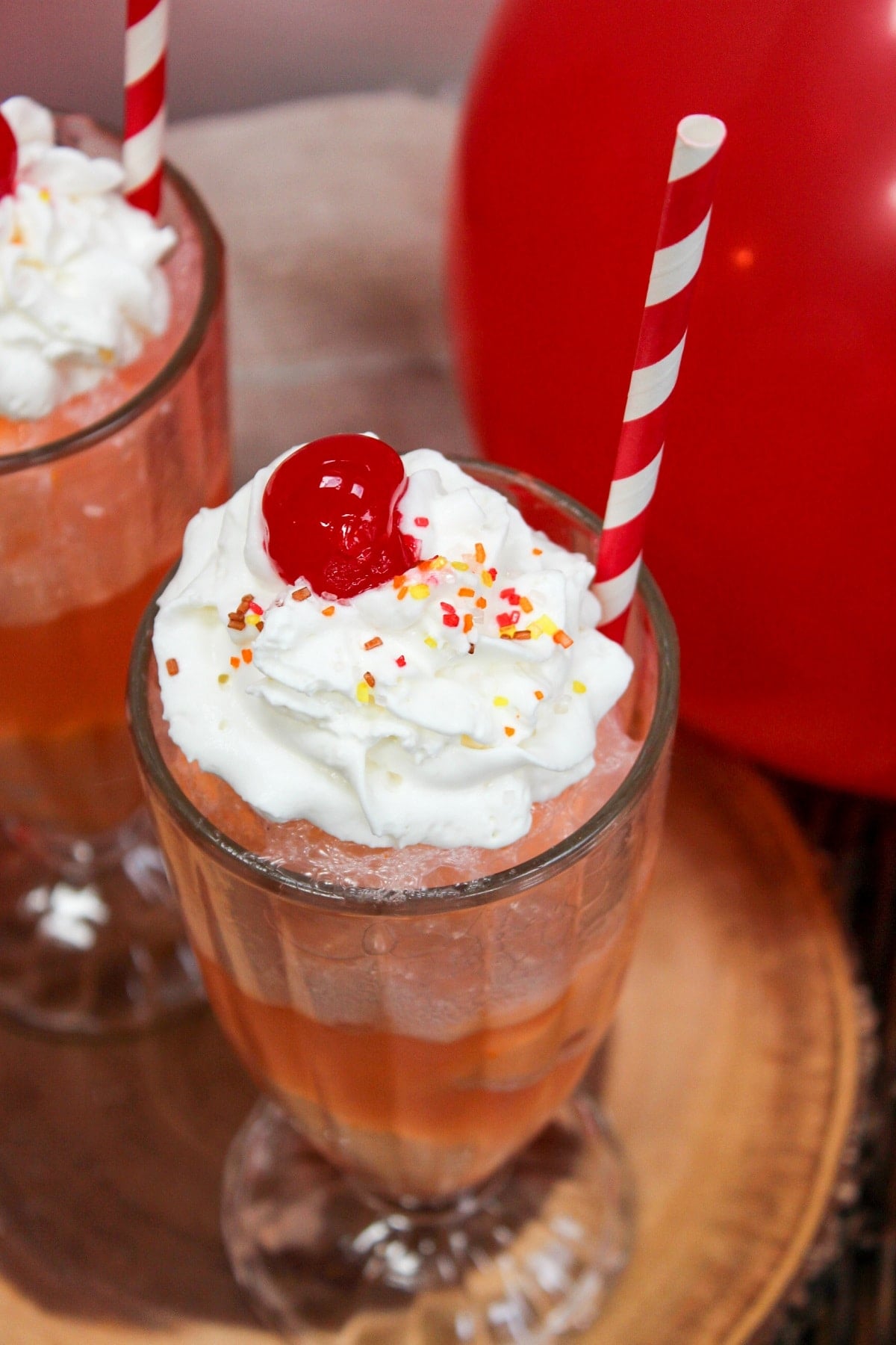 ice cream float in a glass with whipped cream and a cherry