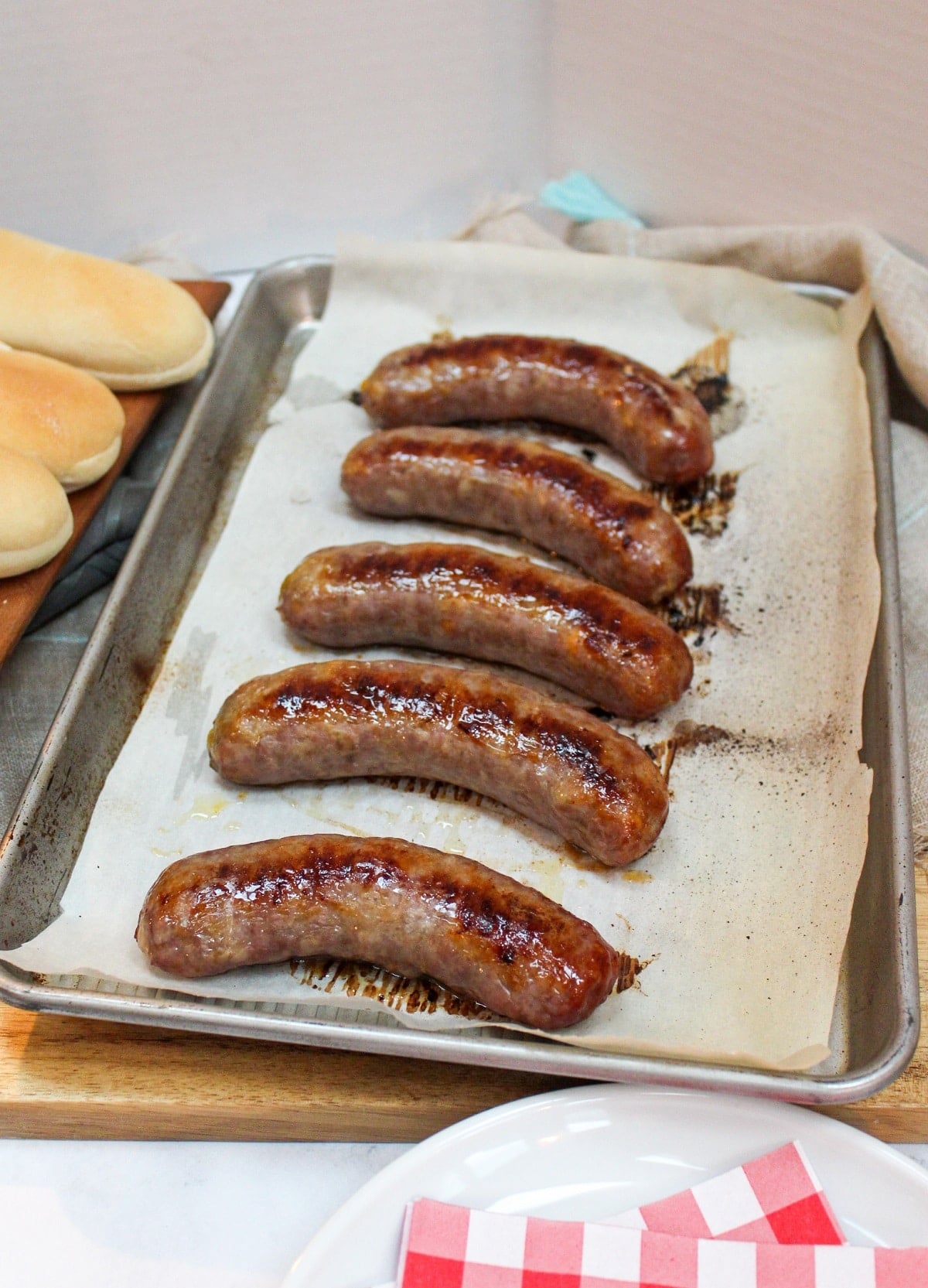 oven baked brats on a baking sheet