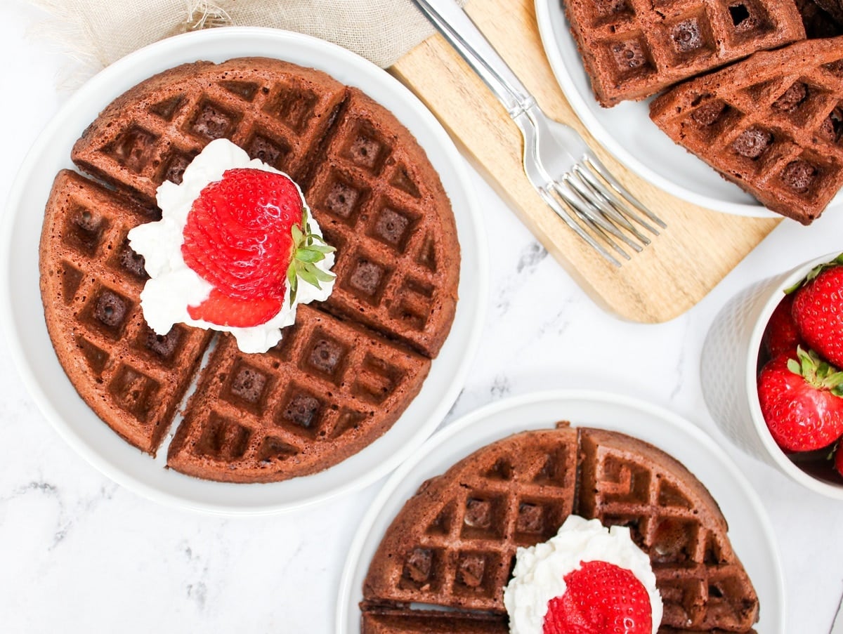 overhead photo of brownie mix waffles topped with whipped cream and strawberries