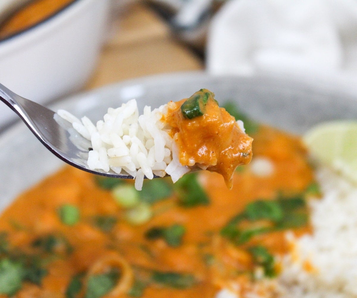 thai butternut squash curry in a bowl with a fork scooping from the contents of the bowl
