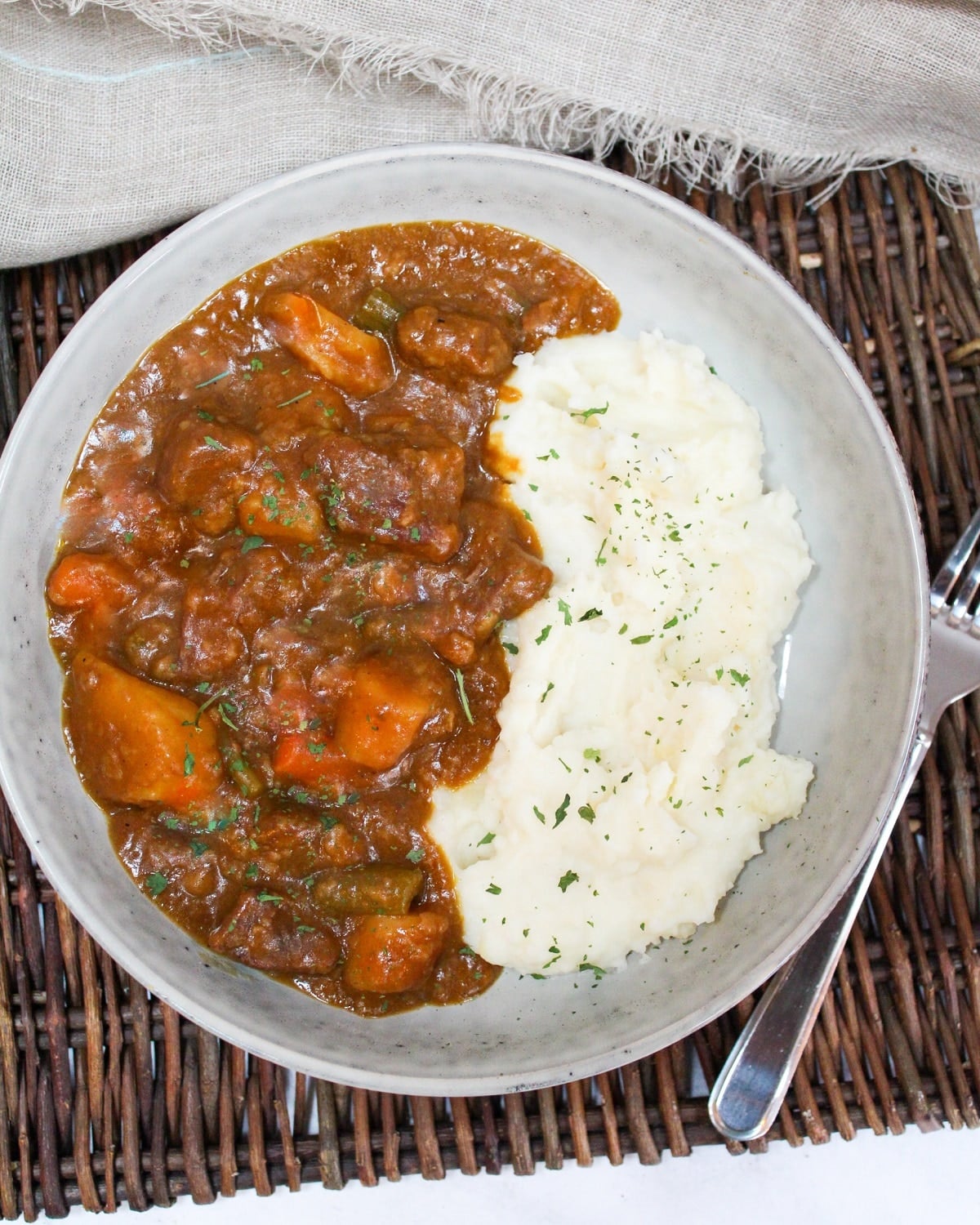 pumpkin beef stew in a gray bowl with mashed potatoes