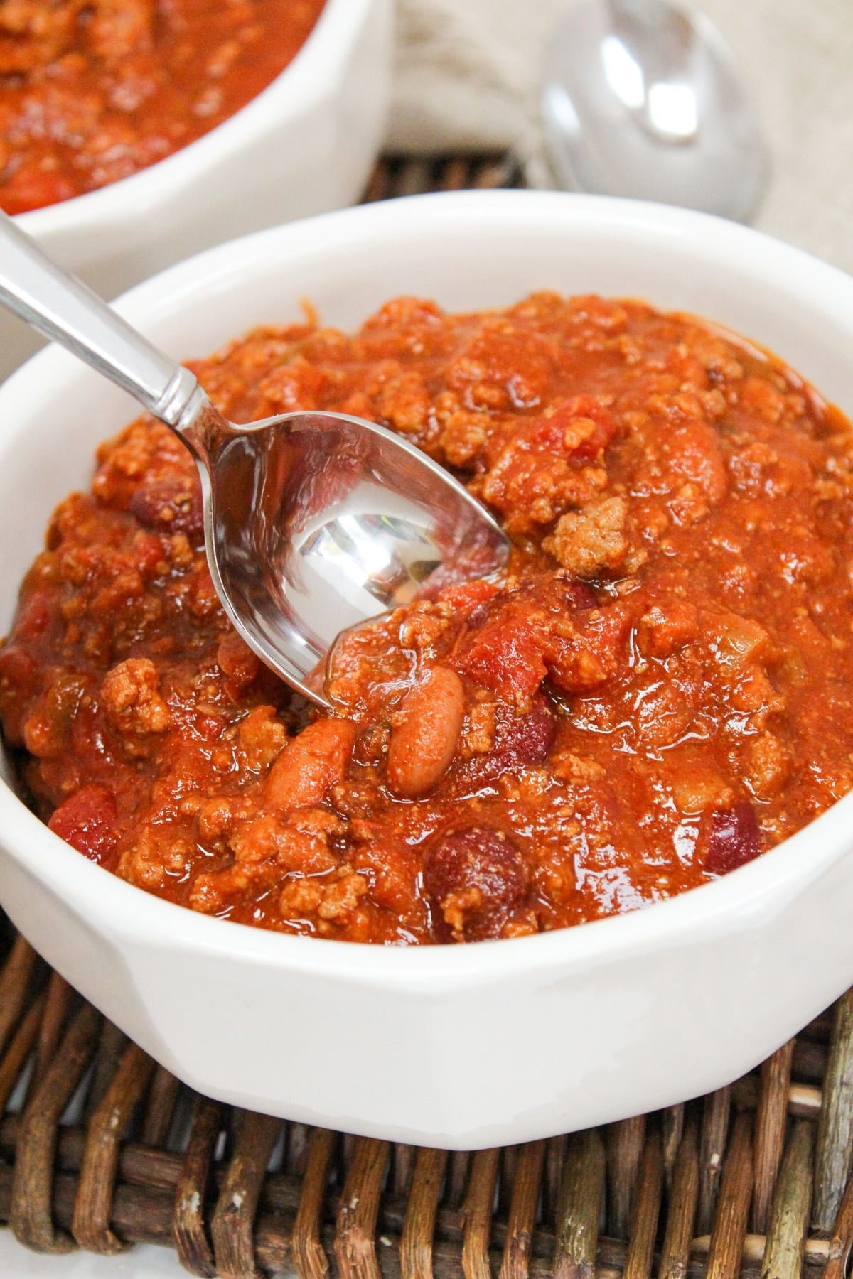 venison chili in a white bowl with a spoon