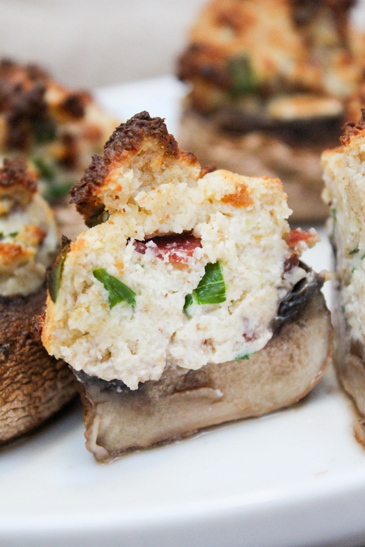 air fryer stuffed mushroom on a white plate cut in half