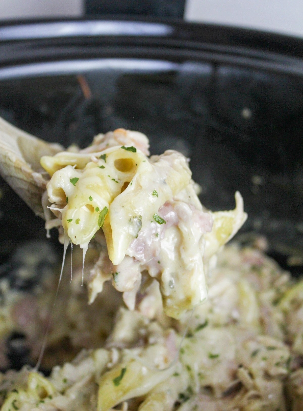 chicken cordon bleu pasta on a wooden spoon
